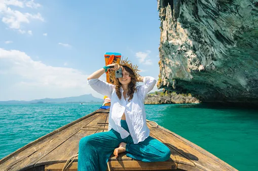 cheerful woman traveling with thai taxi boat and photographing with point and shoot camera