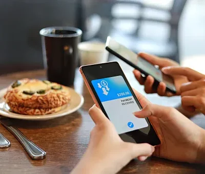 friends splitting bill sending and receiving payment of the meal through digital wallet