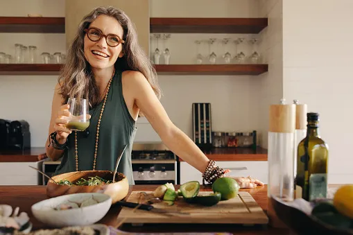 healthy senior woman smiling while holding some green juice