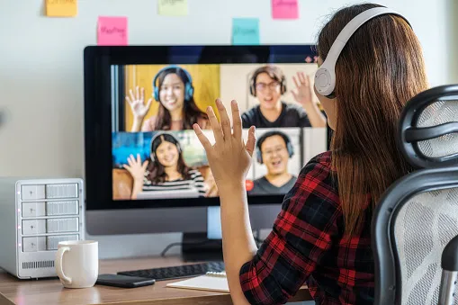 rear view of asian business woman say hello with teamwork colleague in video conference