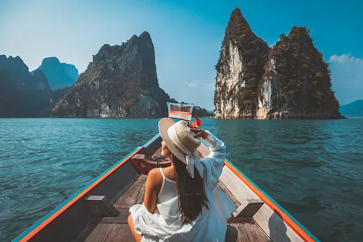 traveler asian woman relax and travel on thai longtail boat in ratchaprapha dam at khao sok