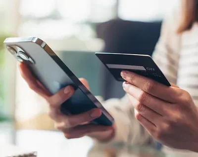 woman hand holding credit cards and using smartphone for shopping online with payment on