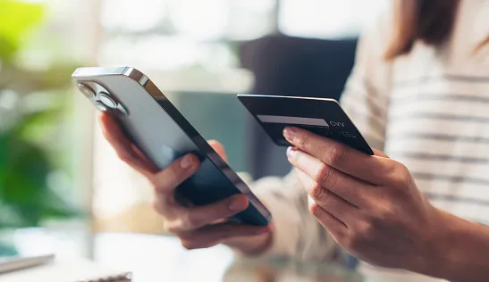 woman hand holding credit cards and using smartphone for shopping online with payment on